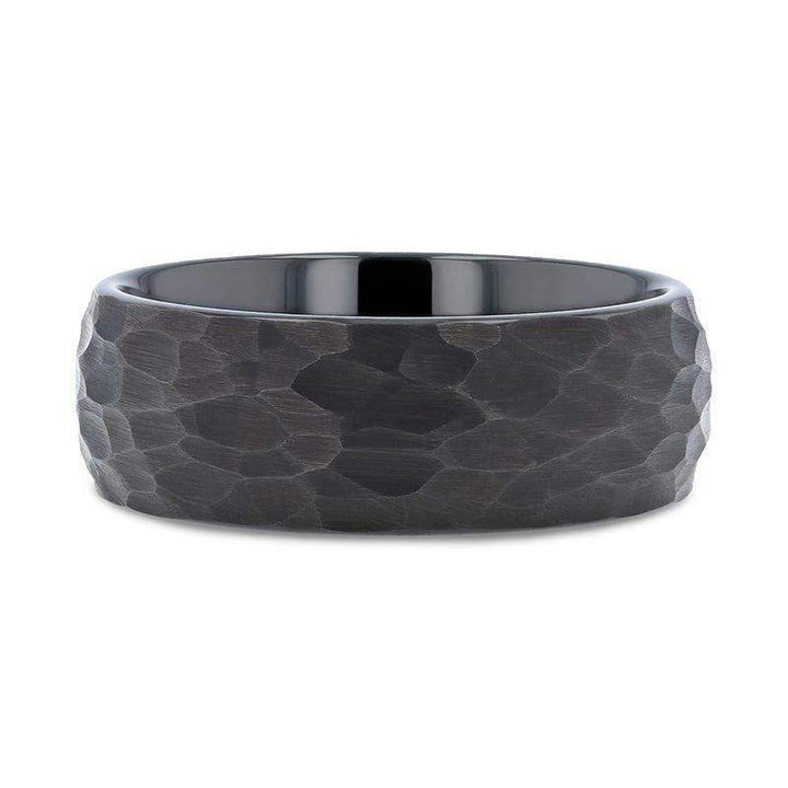 Flat lay of the RENEGADE black tungsten carbide band displaying the hammered, brushed surface and comfort-fit interior